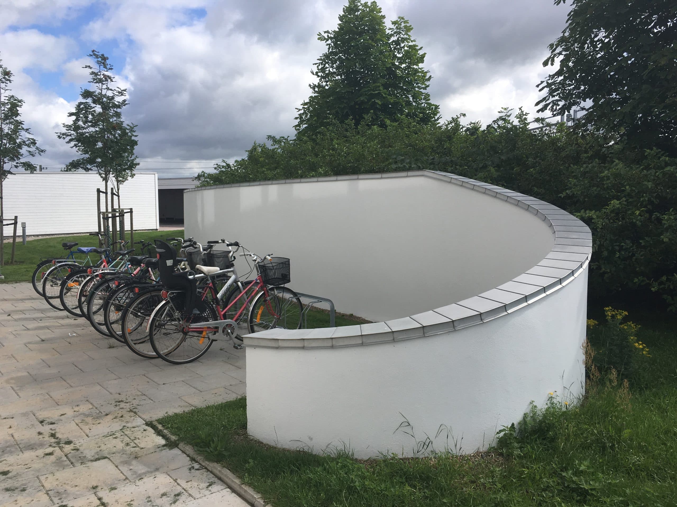 Krönbeslag längs en svängd mur vid ett cykelställ