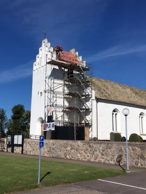 Kyrkan med ställning kring tornet under takarbetet. Bild 1 av 7