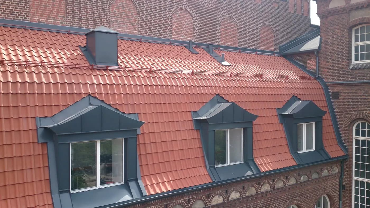Två plåtklädda kupor infällda i det tegelröda taket. Bild 2 av 5