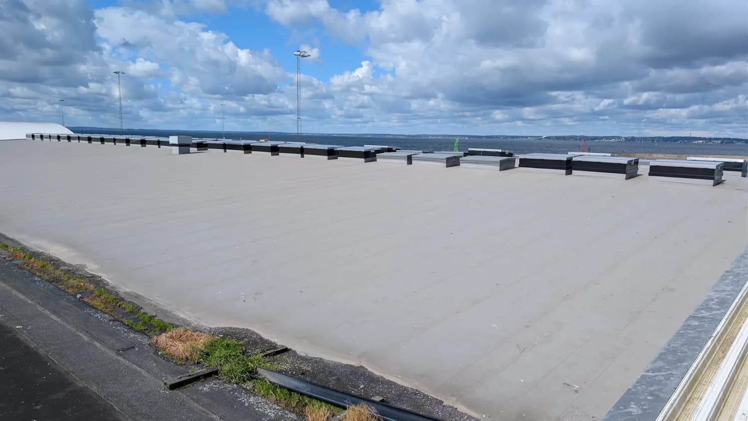 Det stora taket sett mot Öresund, med rökluckor i rad längs kanten. Bild 3 av 5