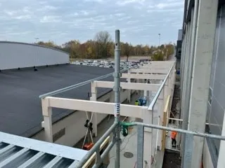 Takarbete pågår över ett parkeringsdäck med limträbalkar. Bild 8 av 8