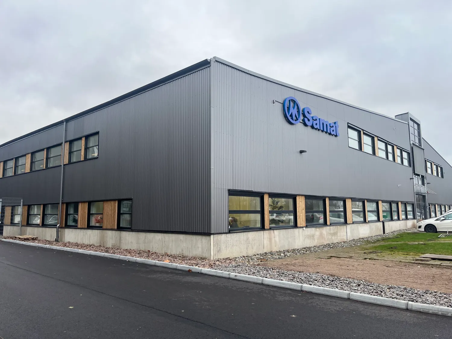 Färdig industribyggnad med grå sandwichfasad och kundens skylt på gaveln. Bild 1 av 1