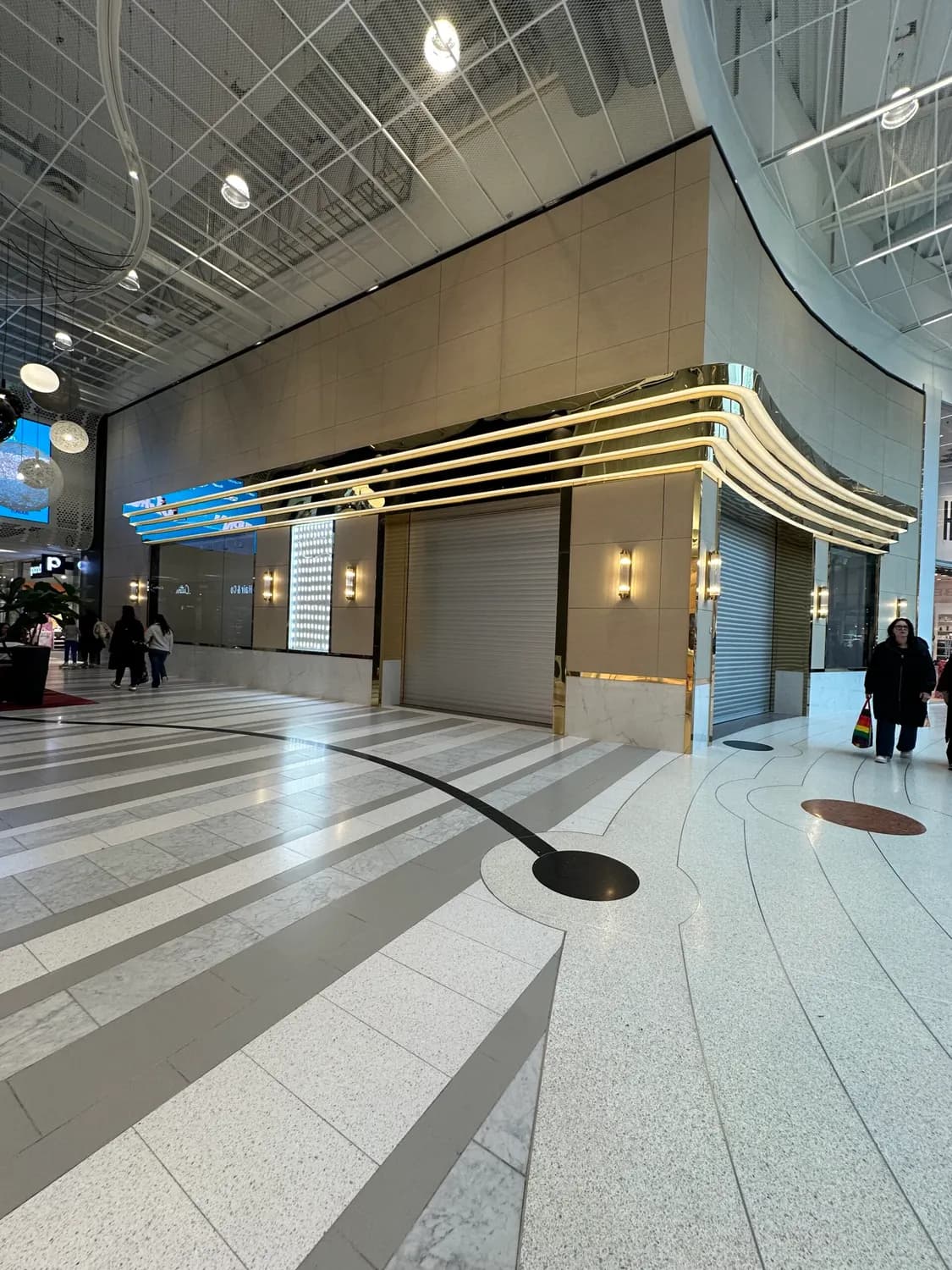Butiken sedd på avstånd i gallerians gång, med belysta lister. Bild 7 av 8