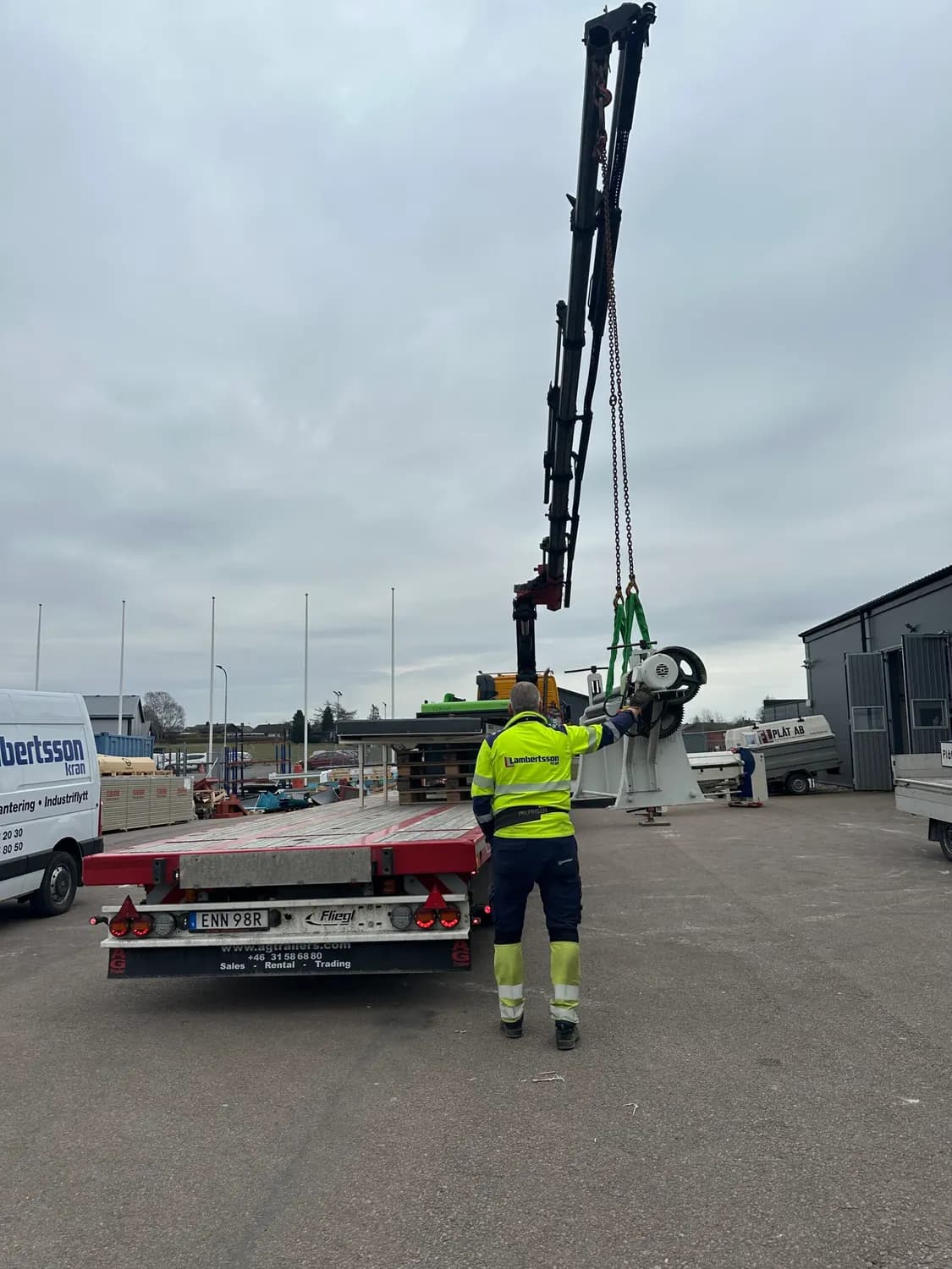Plåtslagare som kopplar ett lyft vid ett tomt lastbilsflak. Bild 13 av 16