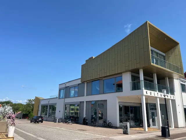 Hela byggnaden från gatan, med cyklar utanför entrén. Bild 20 av 21