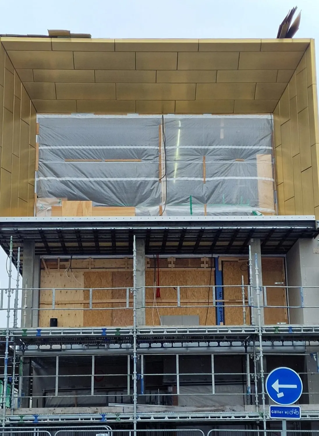 Stort fönsterparti infattat i kopparskivor, inplastat under bygget. Bild 4 av 21