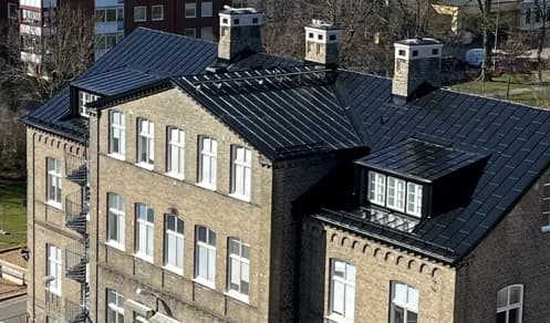 Samma takfall i närbild, med skorstenar och takkupa i plåt. Bild 2 av 5