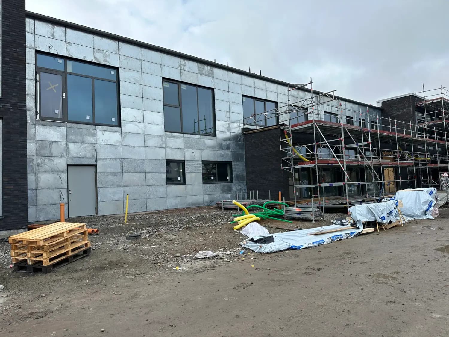 Fasadskivor monterade på baksidan medan ställningen står kvar. Bild 16 av 19