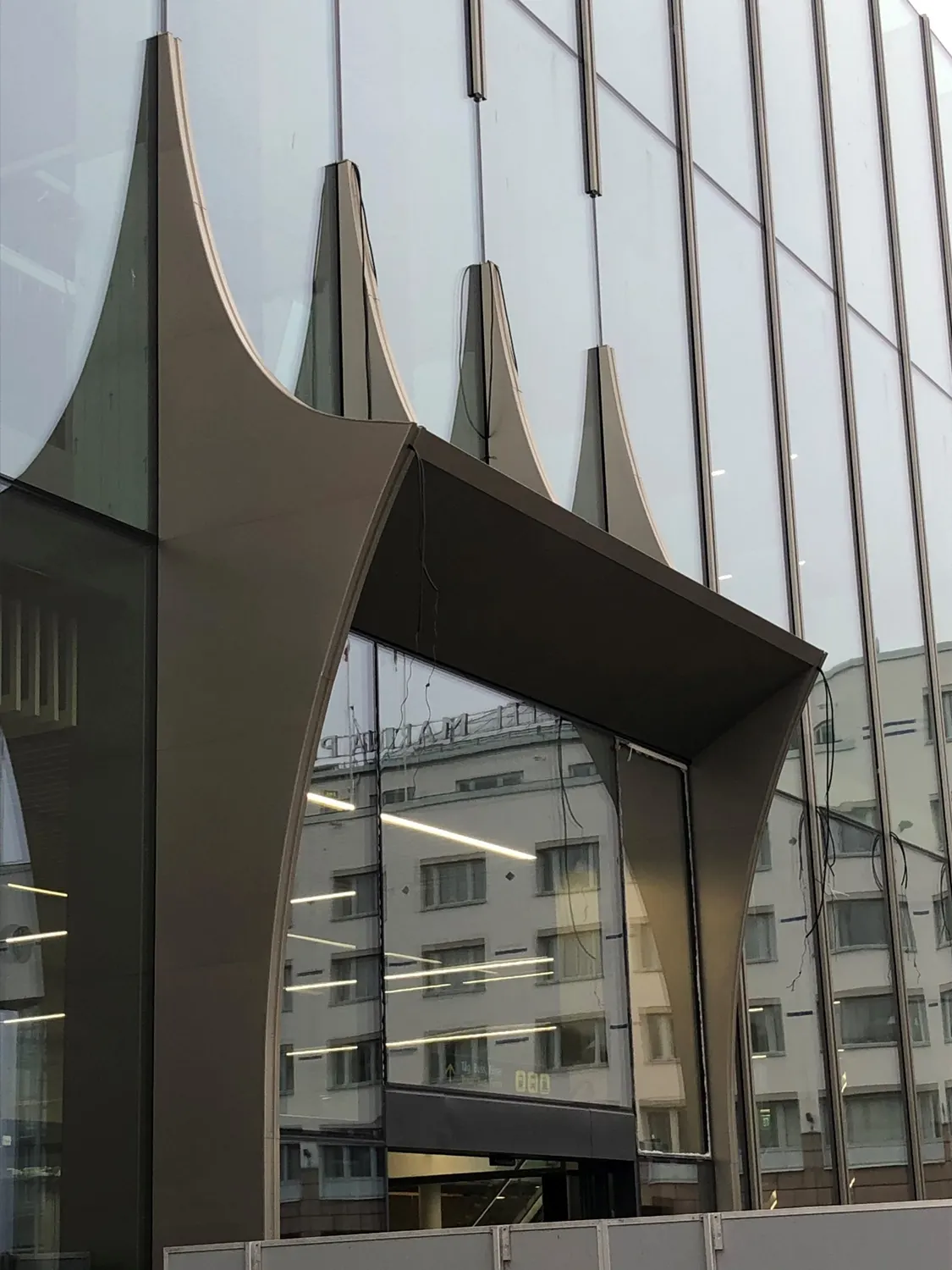 Utkragande fönsterhuv i mörk plåt på den glasade fasaden. Bild 1 av 14