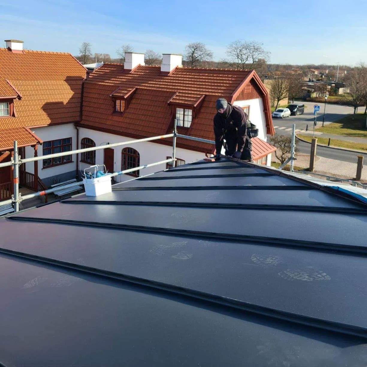 Nylagt tak över en villa vid vattnet, plåtslagare vid nocken. Bild 20 av 62