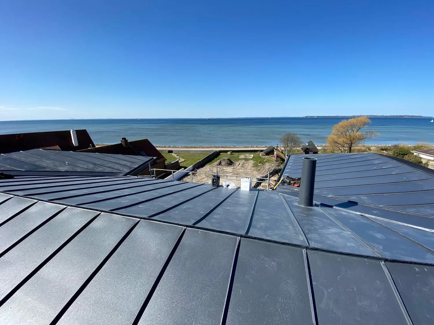 Nylagt tak vid stranden, med havet bortom hustaken. Bild 15 av 62