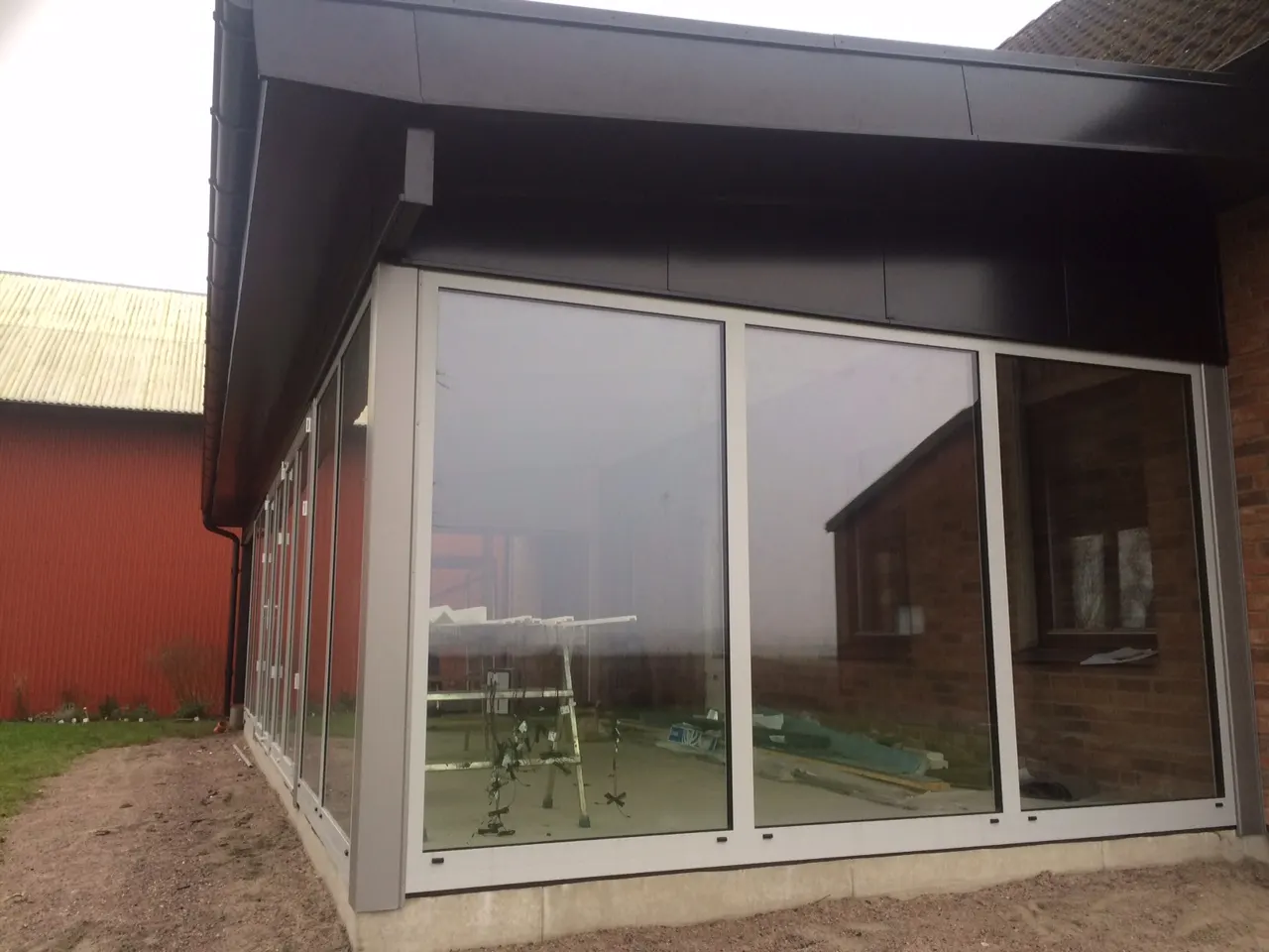 Uterummets glasparti och plåttak sedda från gaveln. Bild 33 av 62