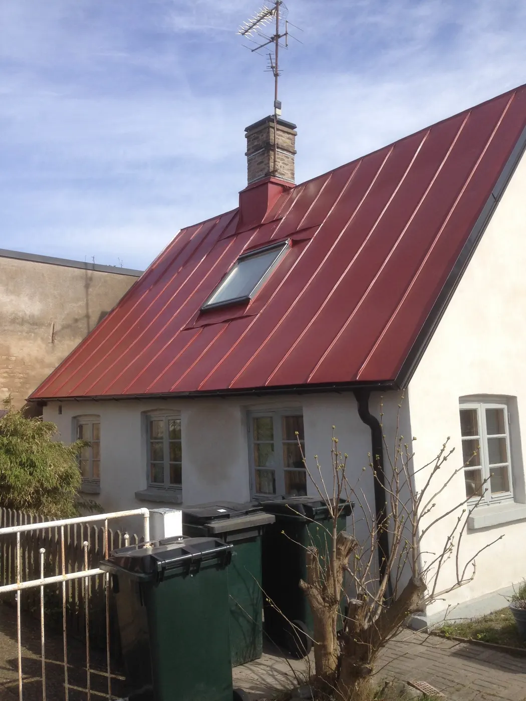 Villa med rött bandtäckt tak, skorsten och takfönster. Bild 34 av 62