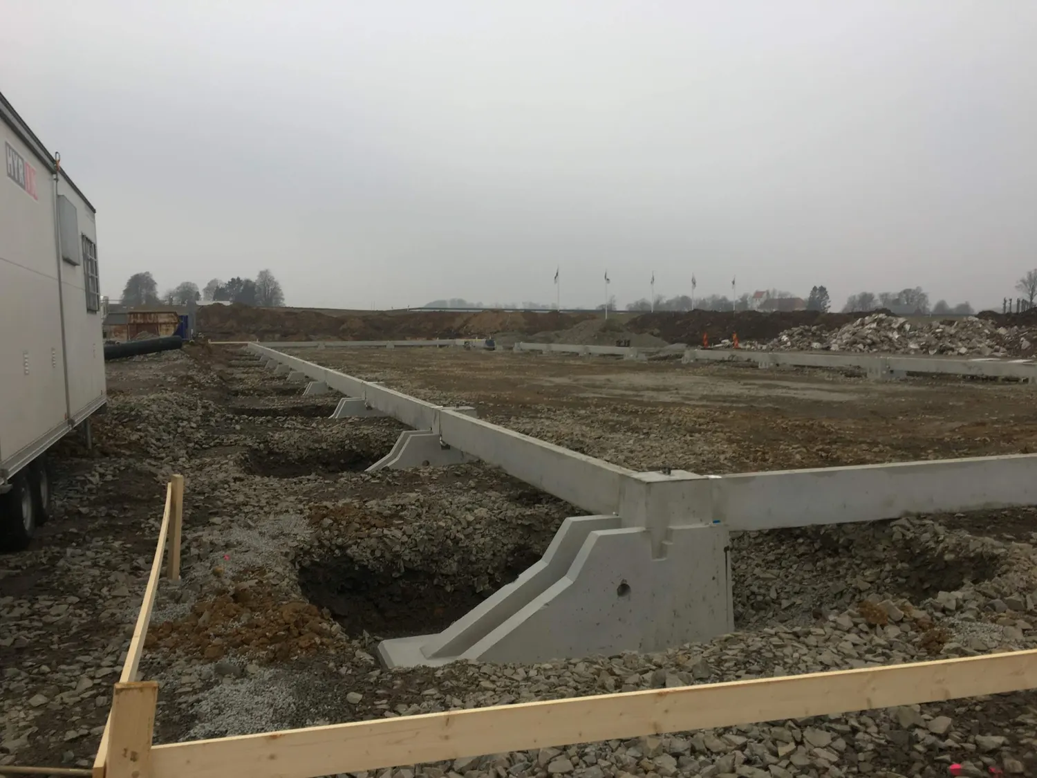 Grundens betongelement resta längs husets långsida. Bild 6 av 23