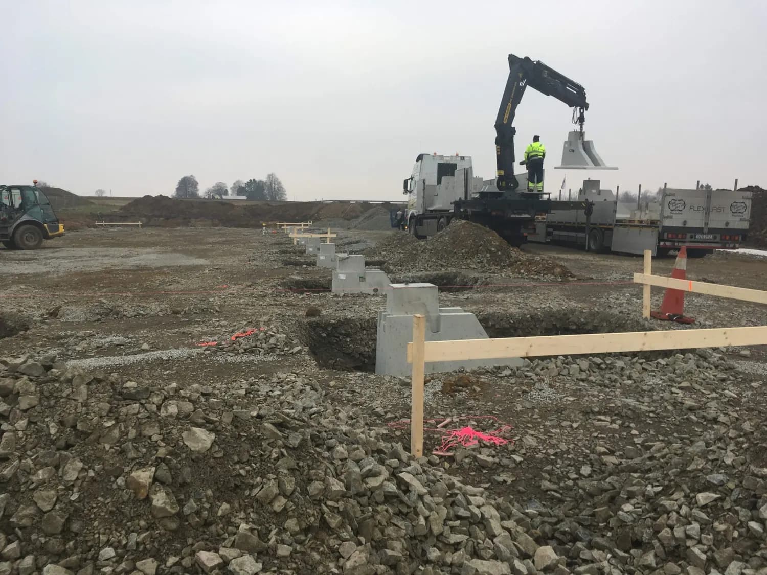 Kranbil lossar betongelement vid grunden. Bild 8 av 23
