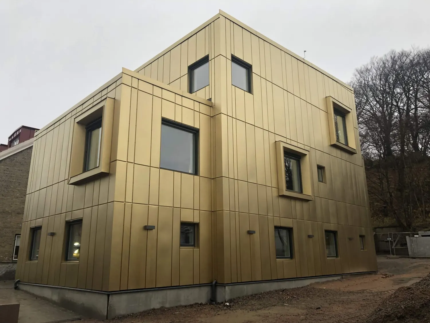 Fasaden rakt framifrån med fönstren infattade i djupa plåtnischer. Bild 8 av 11