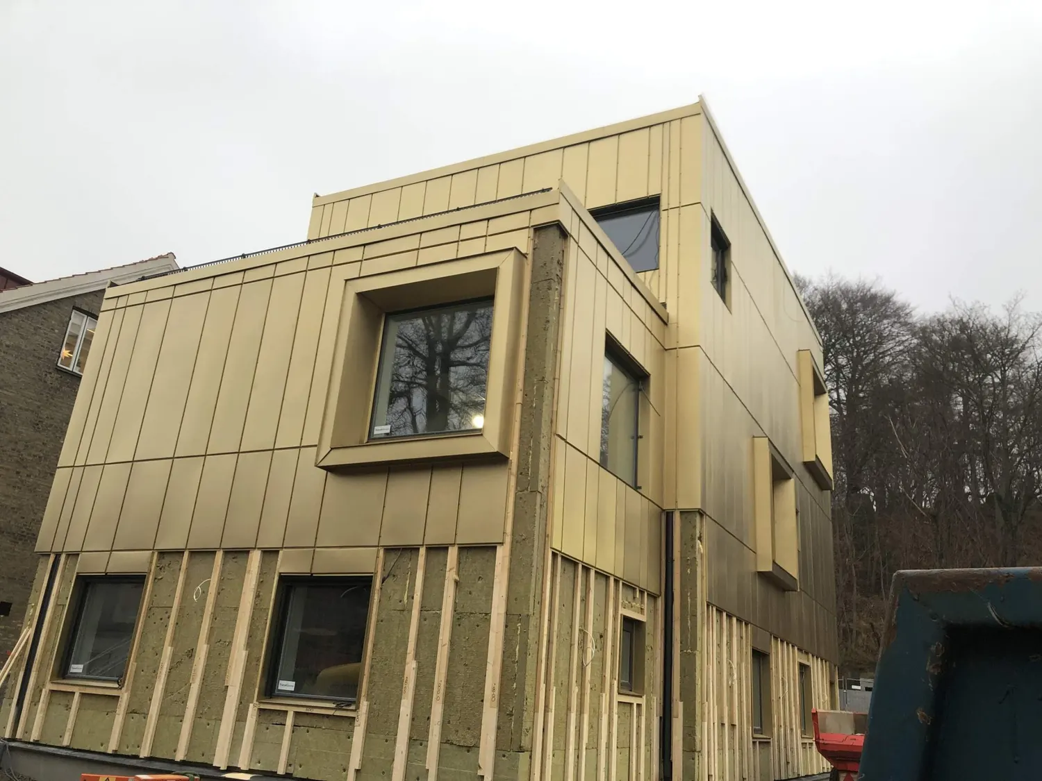 Tillbyggnaden halvklädd, med reglar och isolering synliga nedtill. Bild 2 av 11