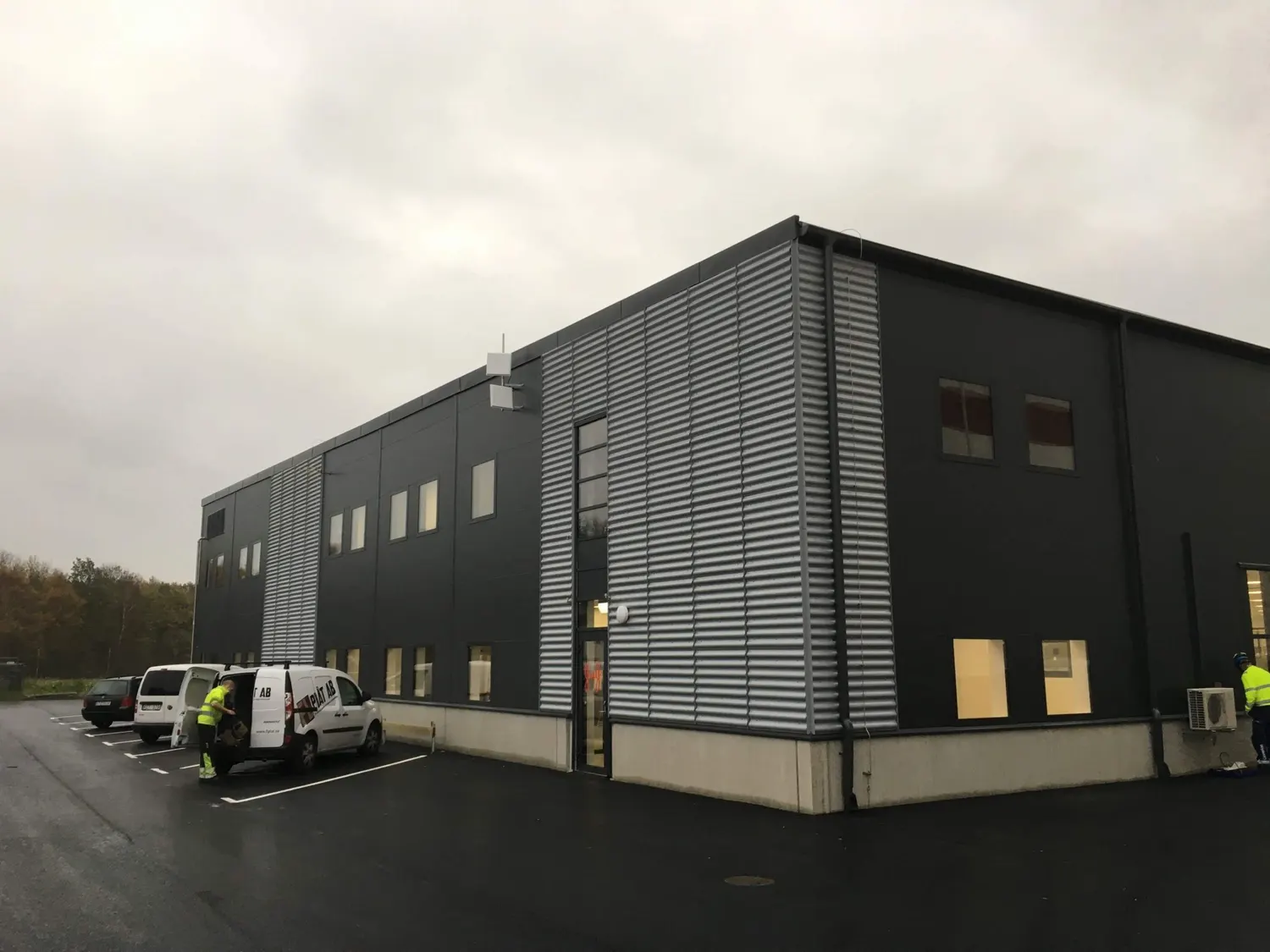 Hela byggnaden från parkeringen, med firmans bil framför. Bild 2 av 3