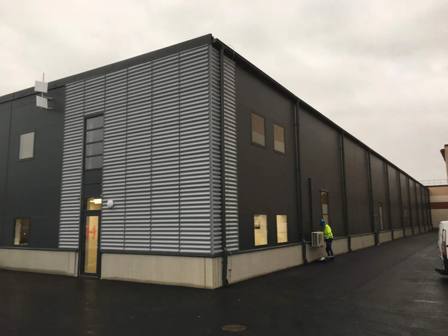 Industribyggnadens hörn med korrugerad och slät plåtfasad. Bild 1 av 3