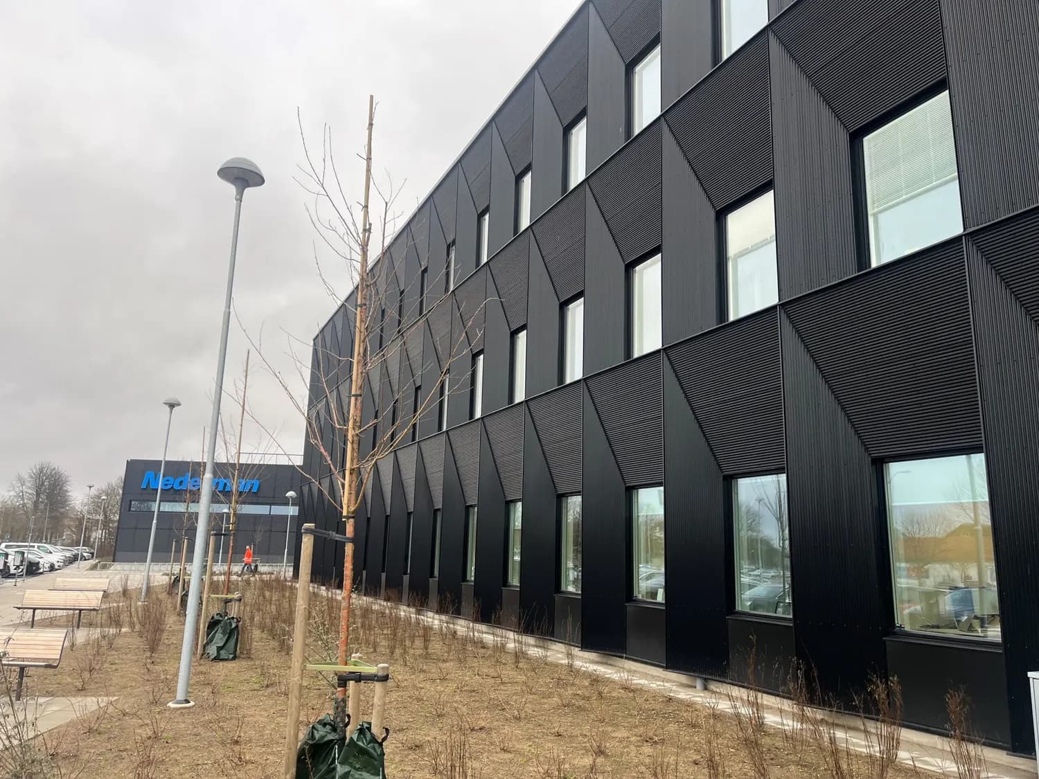 Långsidan med vinklade plåtkassetter kring varje fönster. Bild 3 av 20