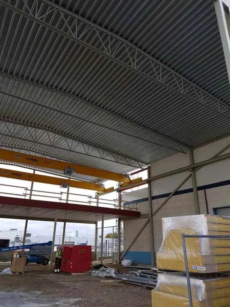 Hallen inifrån med takstolar, travers och trapetsplåt i taket. Bild 3 av 11