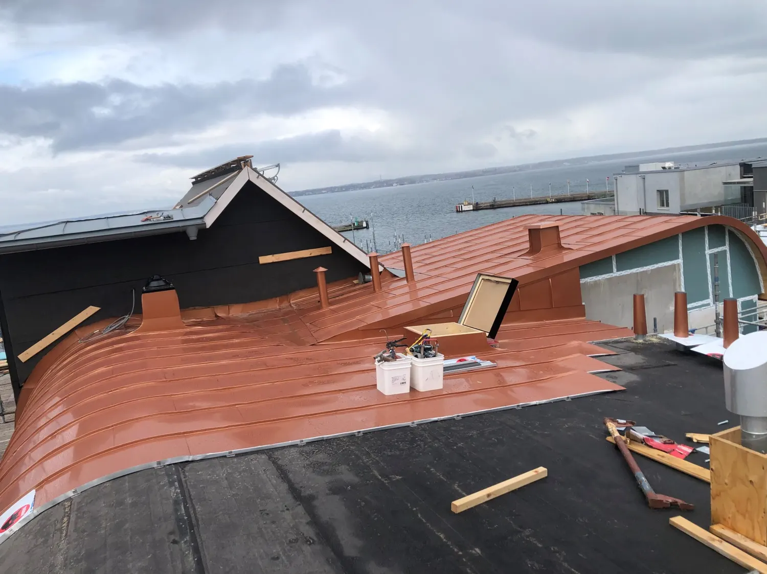Takytan under arbete, med kopparplåt utrullad mot tätskiktet. Bild 20 av 23