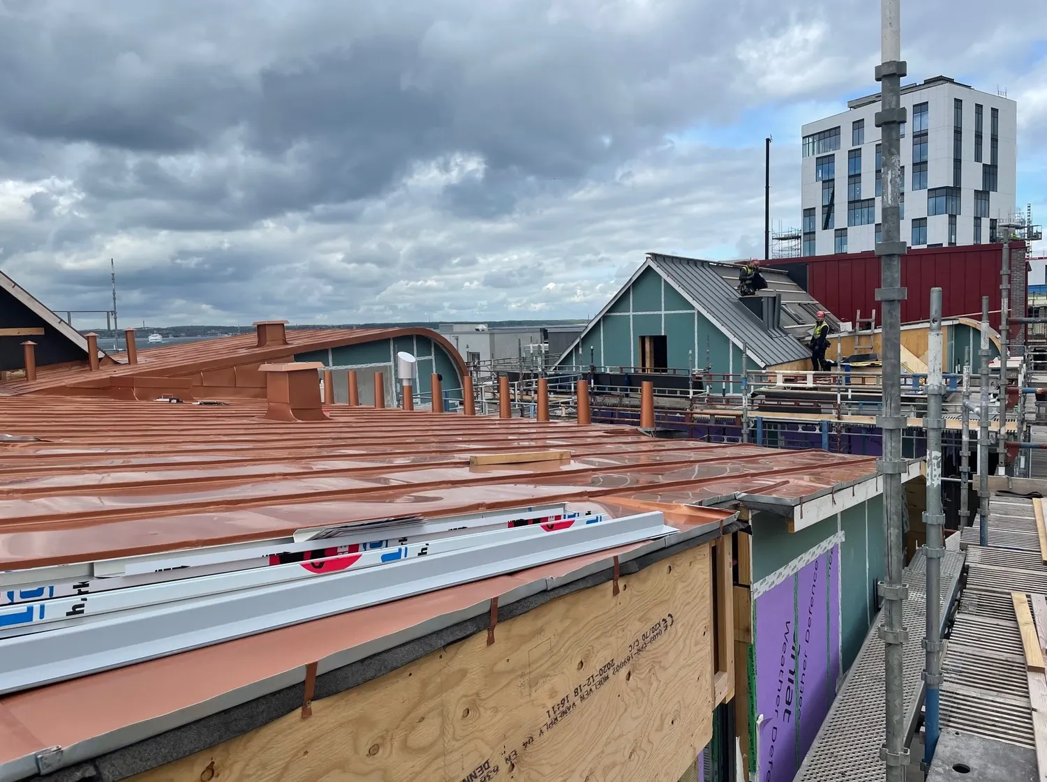 Kopparplåten löper fram mot gavelns kupa längs hela taket. Bild 21 av 23