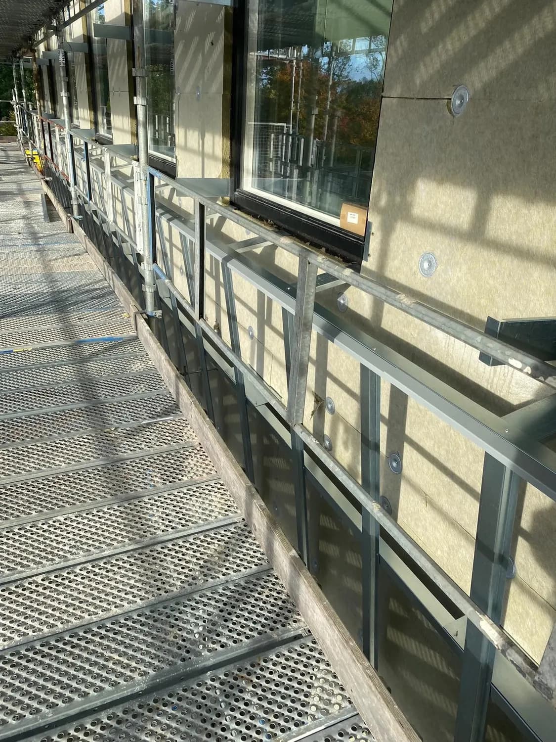 Fasadskiva och fönsterparti sedda från ställningen i motljus. Bild 18 av 20