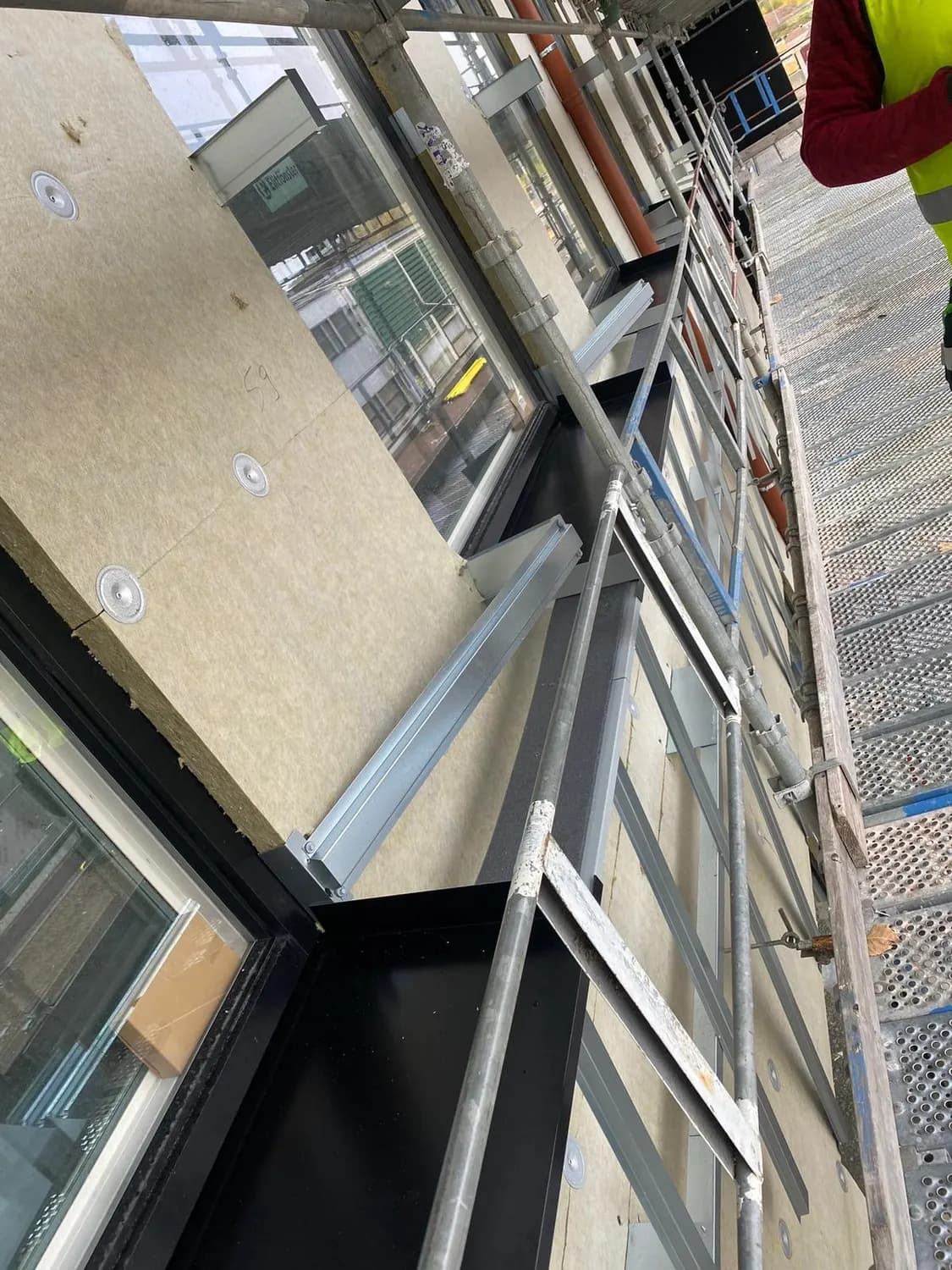 Fönsterpartiernas plåtinfattning under montering, sedd uppifrån. Bild 20 av 20