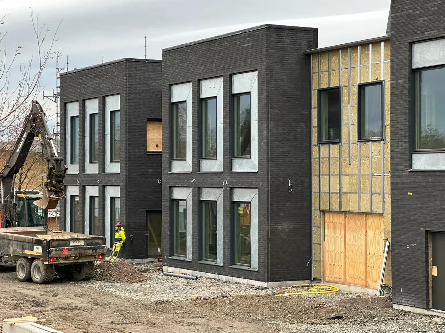 Gaveln med plåtinfattade fönster intill en ännu oklädd vägg. Bild 19 av 19