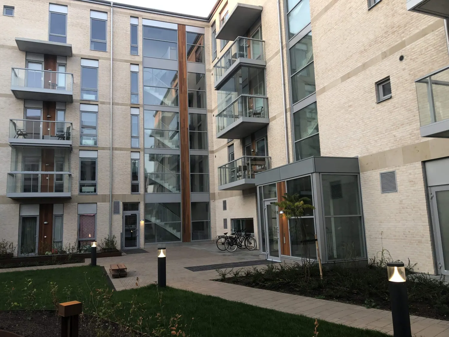Bostadsgården med balkonger och glasat trapphus. Bild 15 av 18