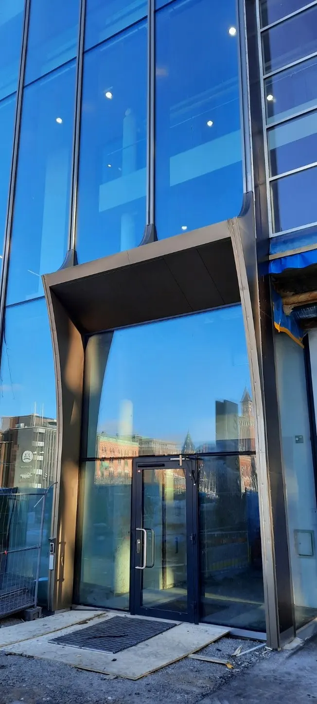 Fönsterhuven inifrån, med stadens hus speglade i glaset. Bild 2 av 14
